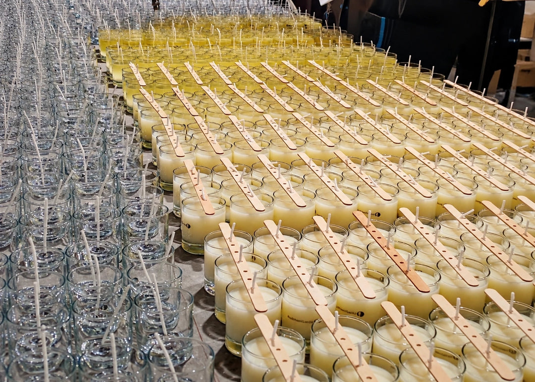 Mesa de producción con un lote de vasos con cera y centradores de pabilo