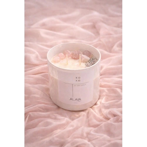 Vela aromática XOXO Alaïa con cuarzos sobre fondo rosa